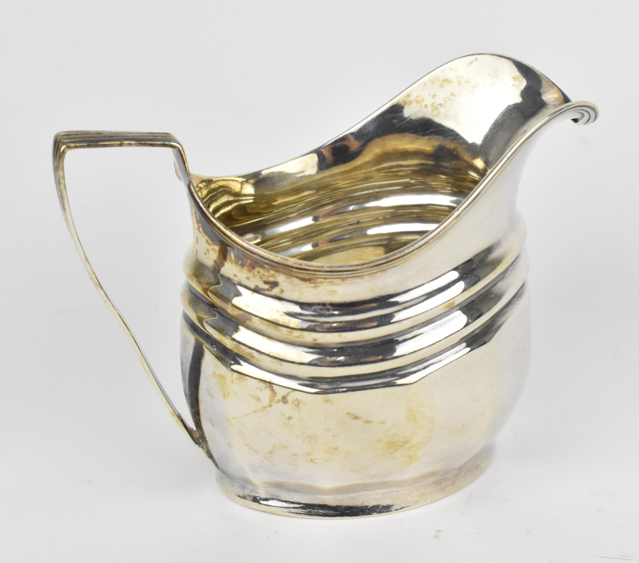 A George III silver milk jug, London 1804, with reeded handle and faceted body, 8.6 cm high,