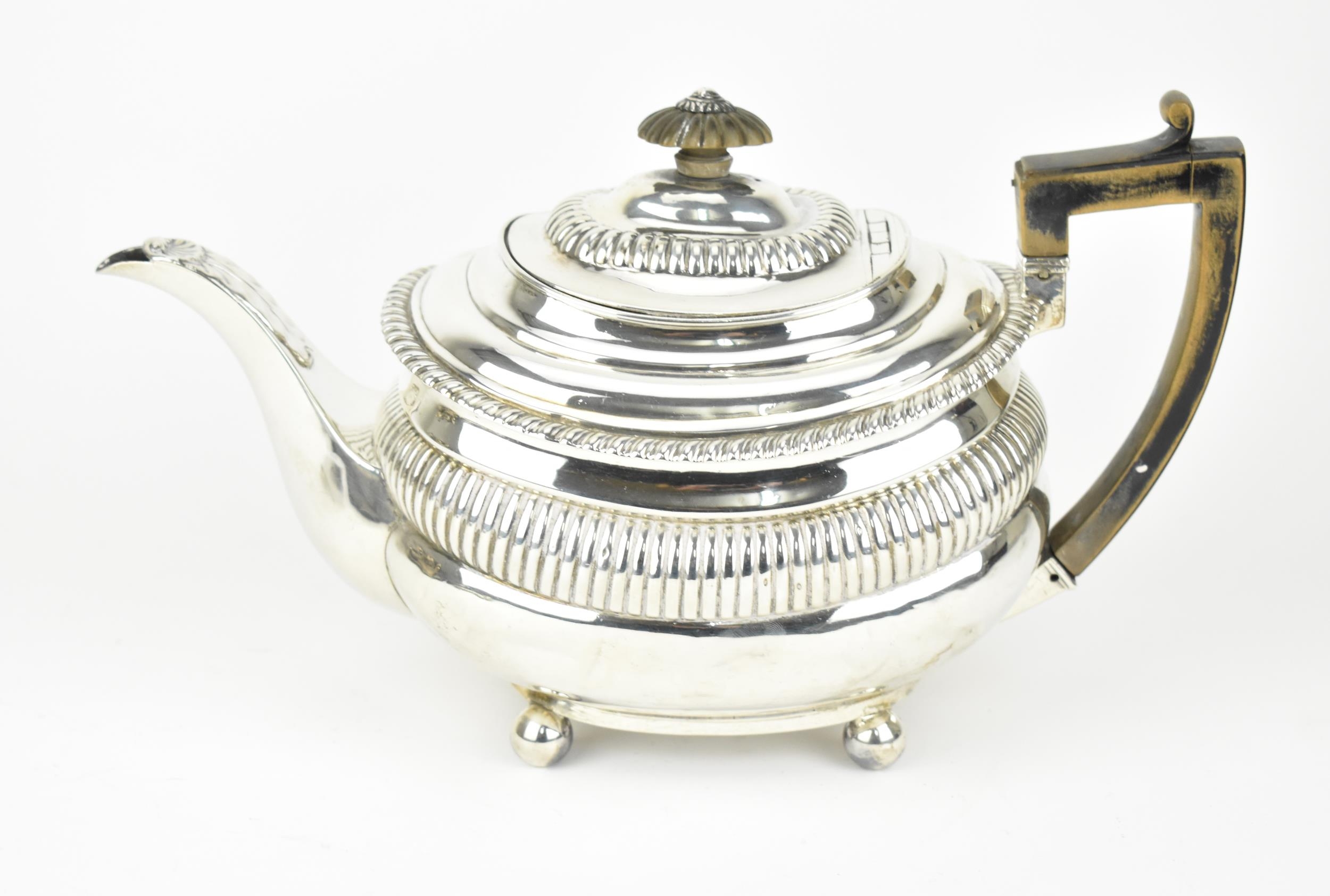 A George III silver teapot, London 1819, with gadrooned rim and wooden final and handle, the spout