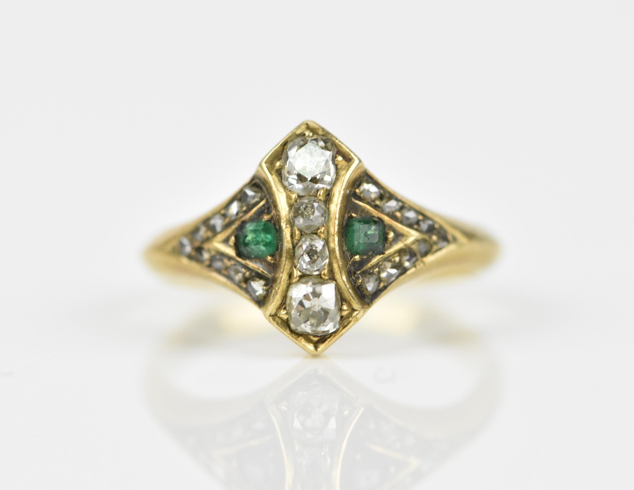 An early 20th century diamond and emerald dress ring, set with four graduated old mine cut