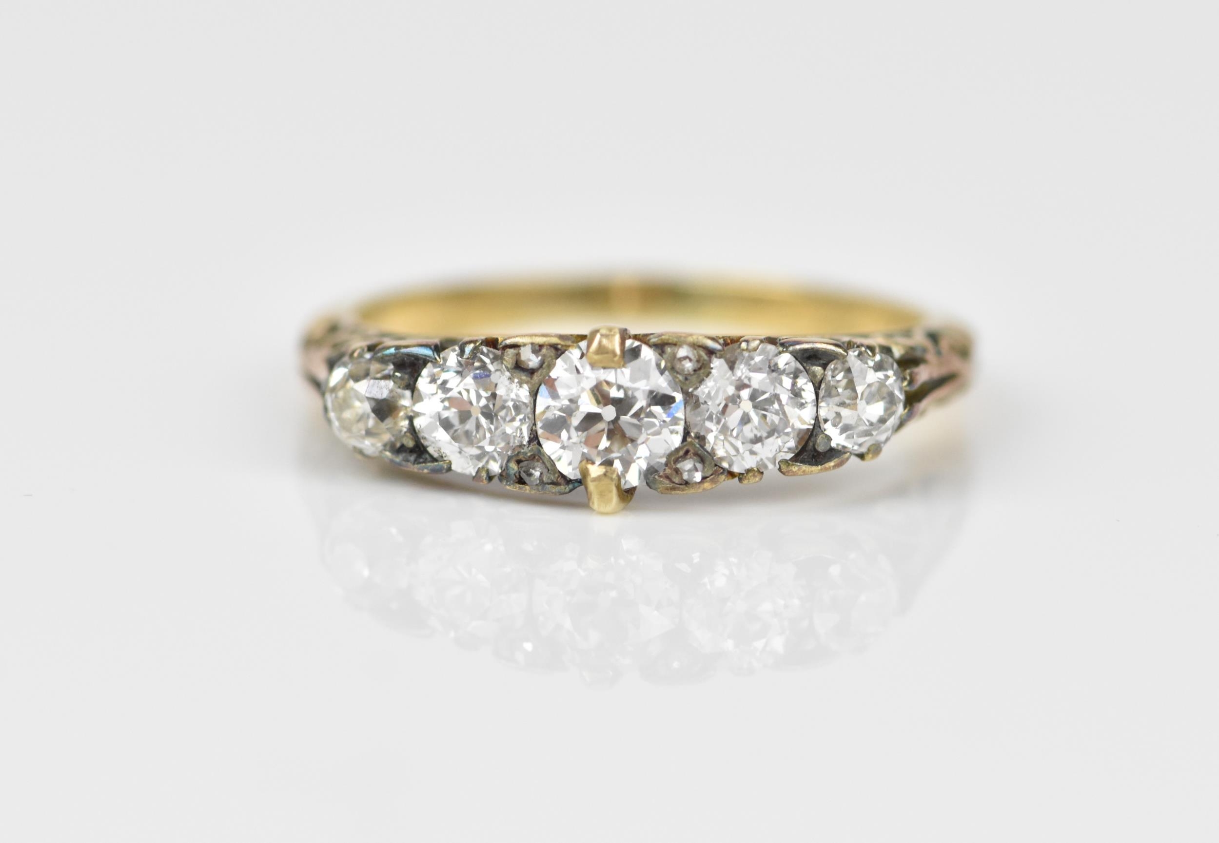 A yellow metal and five stone diamond ring, set with graduated old European cut stones, the