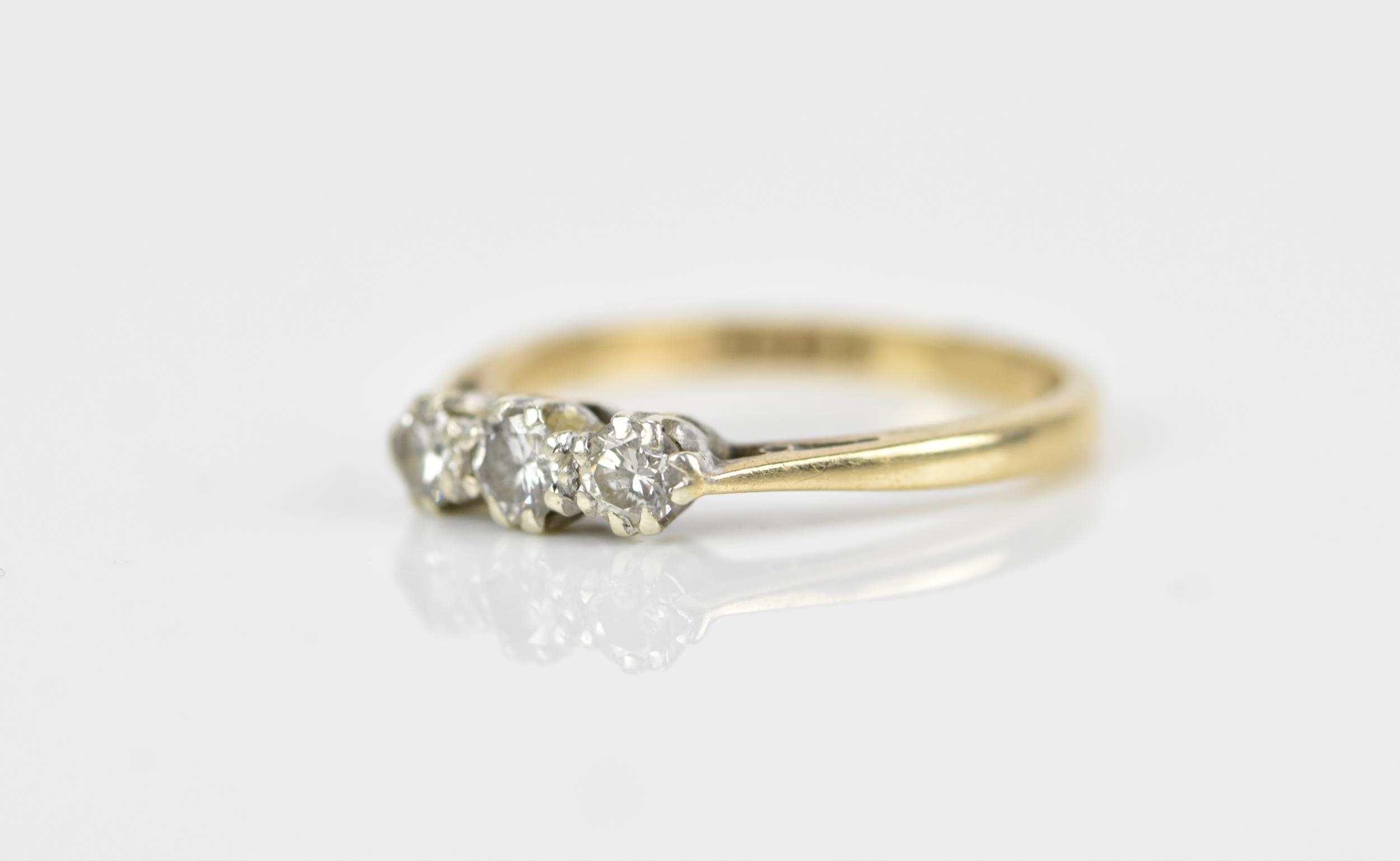 A 9ct yellow gold and three stone diamond ring, all three brilliant stones set in white metal with - Image 2 of 5