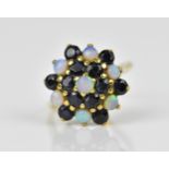 A yellow metal, blue sapphire and water opal dress ring, with cluster design of alternating cabochon