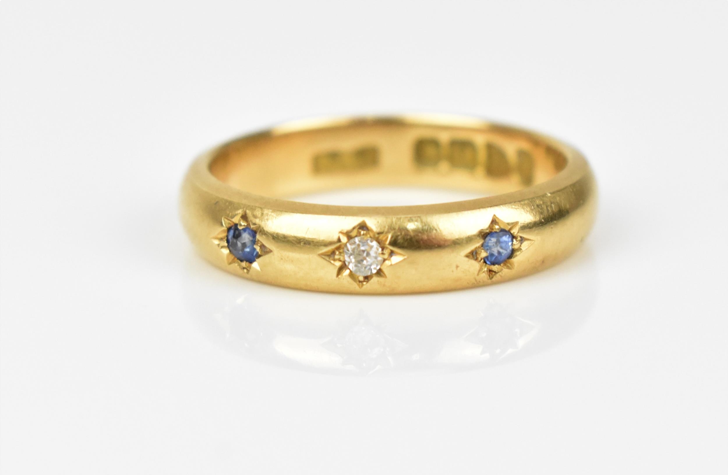 An 18ct yellow gold, diamond and sapphire gypsy ring, set with a central old cut diamond flanked