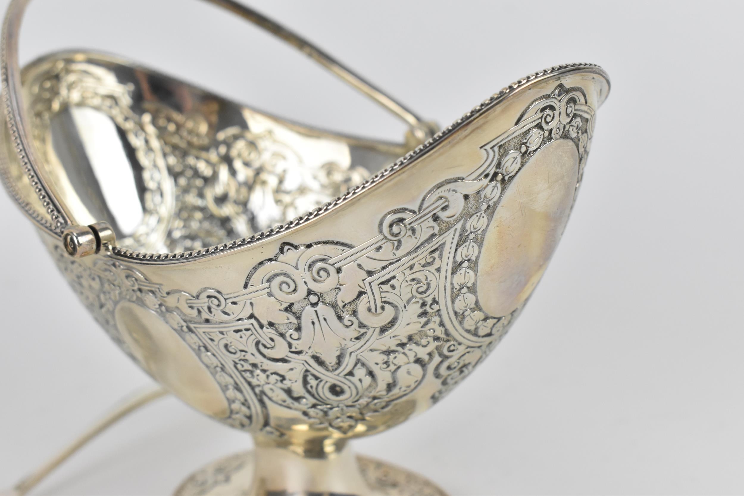 A cased Victorian silver sugar basket, London 1880, of oval form with swing handle, beaded rim and - Image 3 of 8