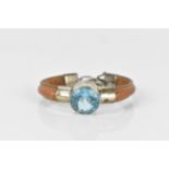 A leather, white metal and topaz bracelet, set with a large round cut blue topaz, in a white metal