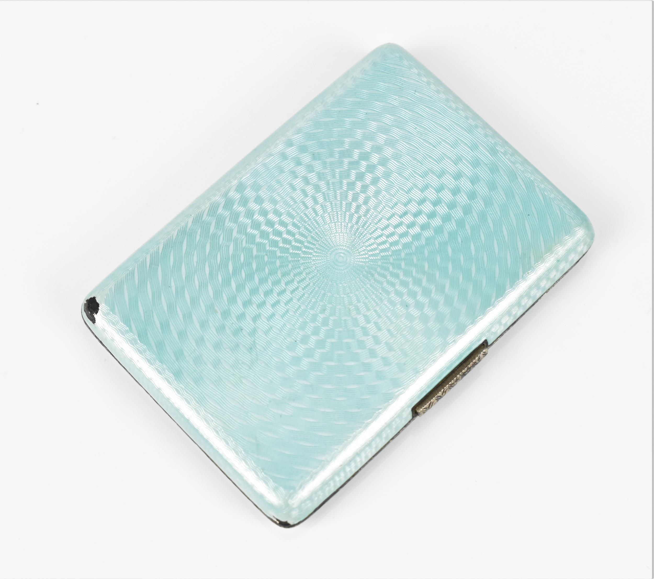 An Art Deco enamelled silver cigarette case, the exterior with engine turned ice blue enamel, with