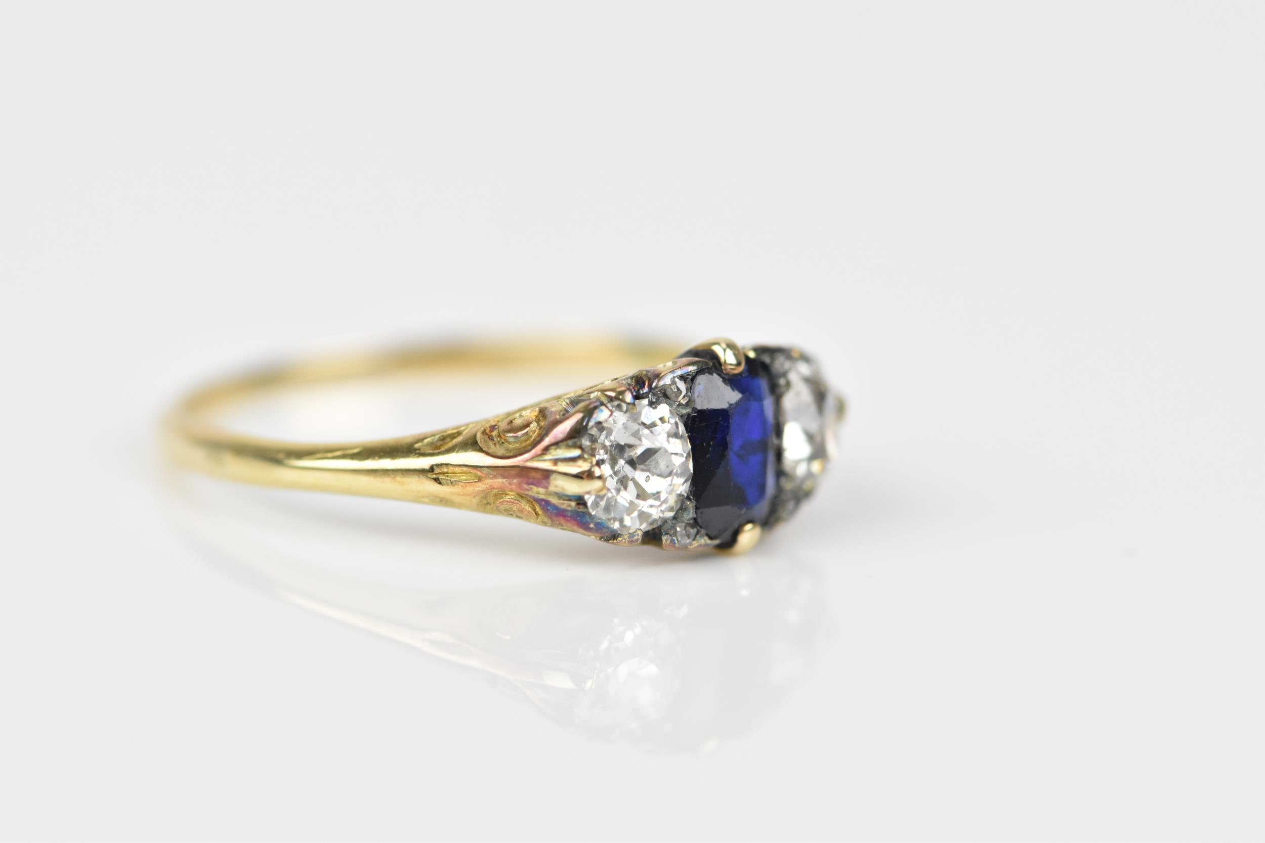 A yellow metal, blue sapphire and diamond dress ring, with central octagon cut sapphire flanked with - Image 3 of 6