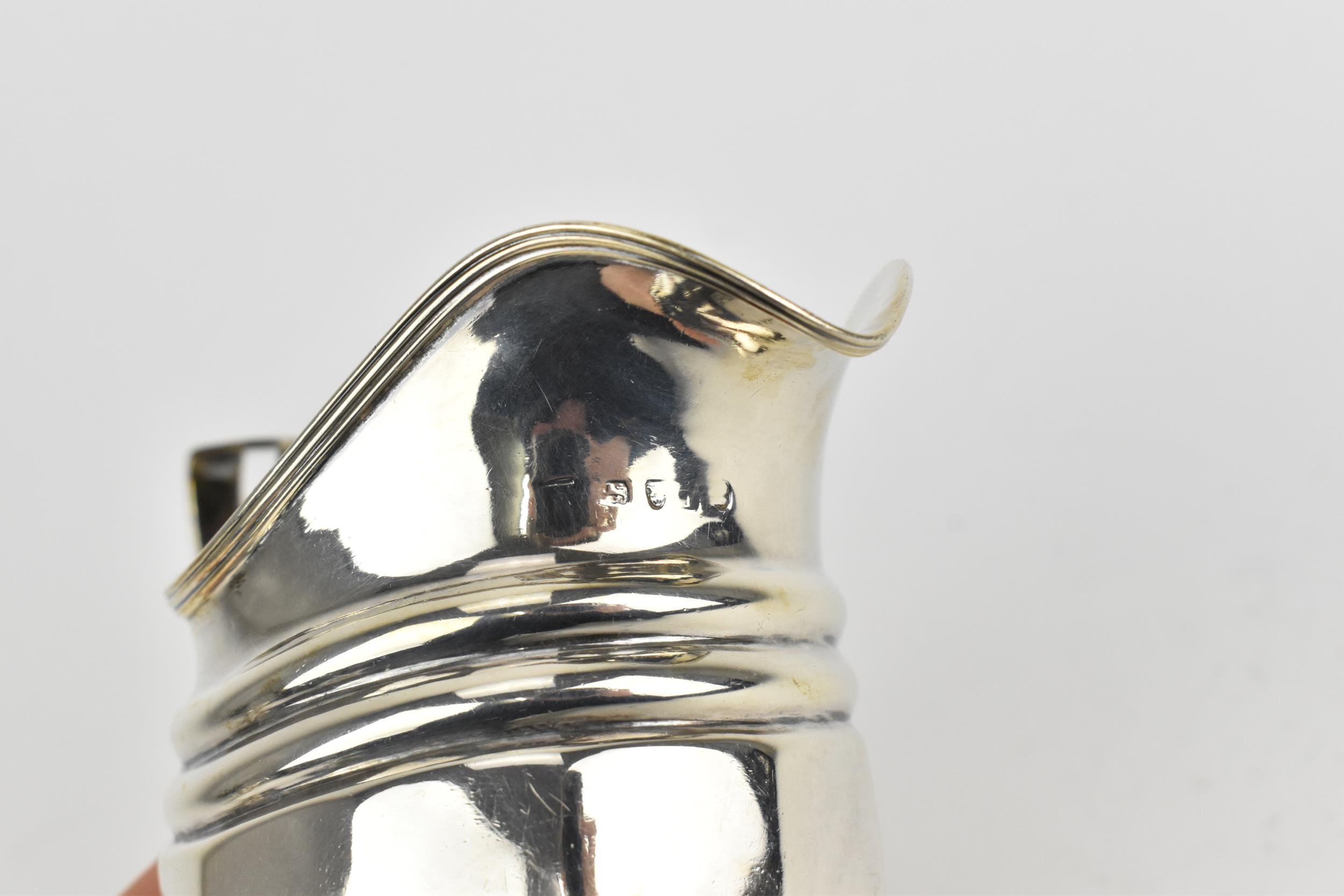 A George III silver milk jug, London 1804, with reeded handle and faceted body, 8.6 cm high, - Image 4 of 4