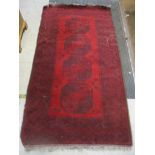 An Afghan handwoven rug, four central elephant gulls on a red ground, triple guard border 205cm x