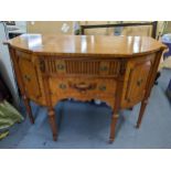 A reproduction satinwood Regency inspired sideboard having two drawers flanked by cupboard doors,