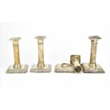 A set of four Edwardian silver candlesticks by William Hutton & Sons, Birmingham 1906, with embossed