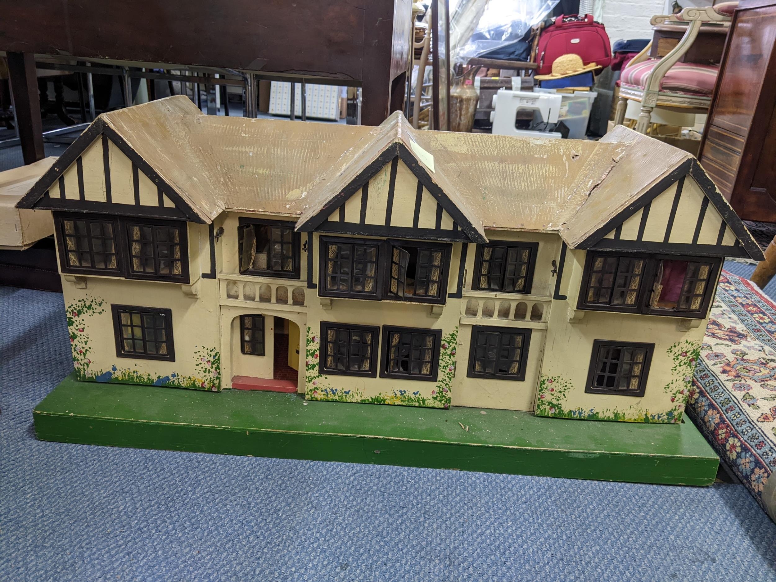 A vintage Triang doll's house on a green painted base 42cm h x 89cm w Location: