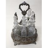 A Victorian silver and wooden cruet stand with seven matching cut glass bottles, two having silver