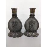 A pair of military related cast metal candlesticks Eneret decorated with a crown 1870-1945 Dev