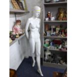 A mannequin in female form standing on a glass base 182cm High together with a contemporary