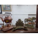 A brass desk set, a brass ornament in the form of a horse a hammered copper kettle on brass stand