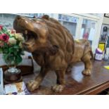 A large carved African wooden lion, 58cm high, 107cm long Location: