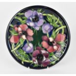 A Moorcroft Pottery circular plate designed by Emma Bossons, in the "Anemone Tribute" pattern, the