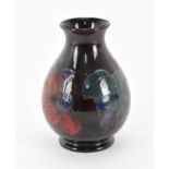 An early 20th century Walter Moorcroft pottery baluster vase, in the 'Clematis' pattern, the