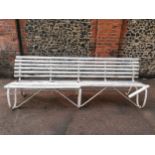 A painted wood and wrought iron slatted garden bench, 87 cm high x 243 cm wide Location: