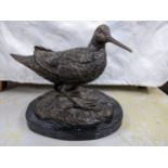 A contemporary bronze sculpture of a Woodcock mounted on an oval black variegated marble base,