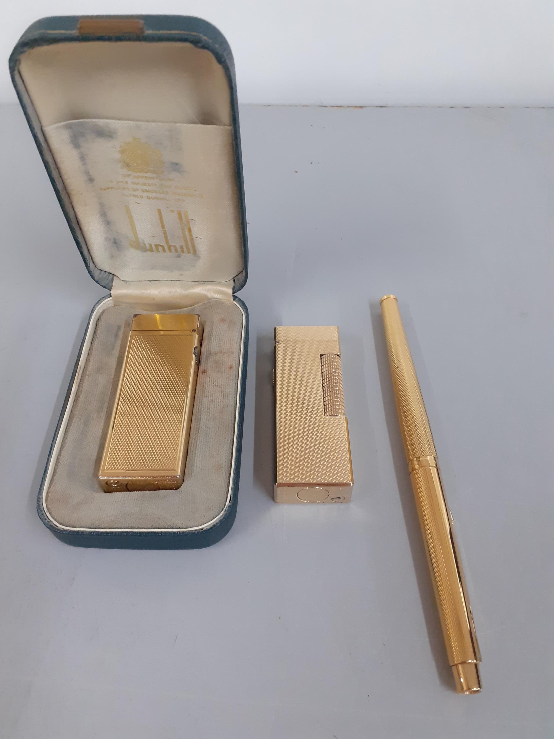 Two gold plated Dunhill cigarette lighters and a gold plated Parker fountain pen Location: