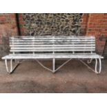 A painted wood and wrought iron slatted garden bench, 87 cm high x 243 cm wide Location: