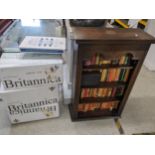 A mid 20th century oak open bookcase containing mixed books together with a collection of boxed