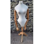 A mannequin/dressmaker's dummy with cloth body and articulated pine jointed arms on an adjustable