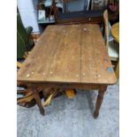 A Victorian pitch pine kitchen table with single drawer and bun handles, rectangular top with shaped