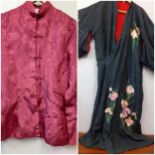 A 20th Century Japanese robe in black silk having hand-embroidered pink flowers and green tubular