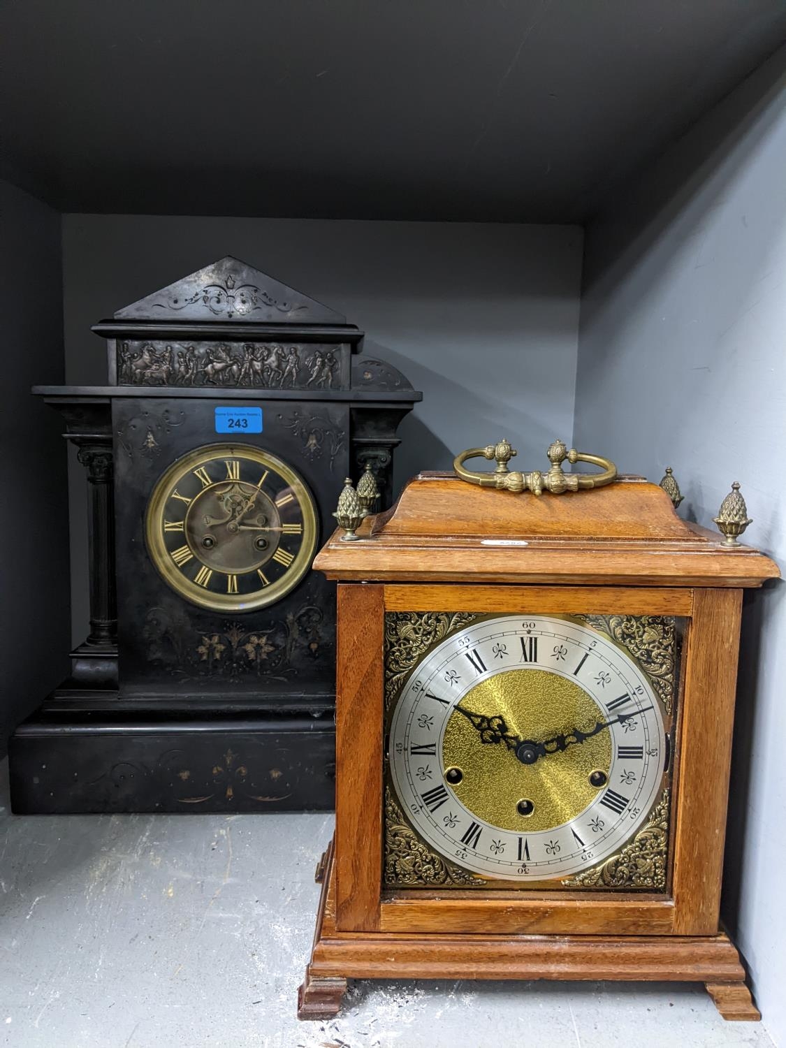 A Victorian black slate mantle clock of classical design with open pillars and frieze above the