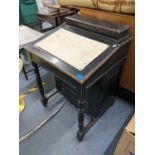 A Victorian ebonized Davenport having a fitted interior and turned pillars, 81h x 56w