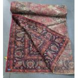 A large hand woven Middle Eastern rug, red ground and floral pattern rug with triple guard border,