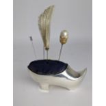 A large Edwardian silver pin cushion/hat pin stand modelled as a shoe, with a turned up toe and