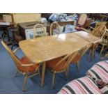 A vintage Ercol blonde elm and beech dining table with extension, together with six spindle back