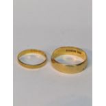 A 22ct yellow gold wide band ring, and a smaller 22ct yellow gold band Location: