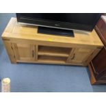 A modern light oak side unit with two central shelves flanked by cupboard doors, 55cm h x 125cm w