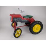 A mid 20th century Triangle red, green and yellow painted metal and plastic peddle tractor, with