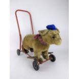 A 1940's Tri-ang, Pedigree push along teddy bear with a red painted metal frame, wooden foot rests