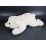 A modern Steiff recumbent polar bear with the button and tag to its ear, 15cm high, 43cm long