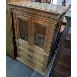 A 19th century walnut cabinet having a carved gadrooned drawer above two glazed doors and three