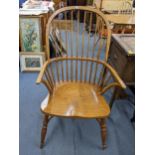 A Windsor spindle back elm seated armchair having crinoline stretcher and turned legs Location: