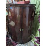 A George III mahogany bow fronted corner cabinet, four internal shelves, brass escutcheons and H