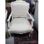 A contemporary white painted open armchair with upholstered back and seat in a dark cream coloured