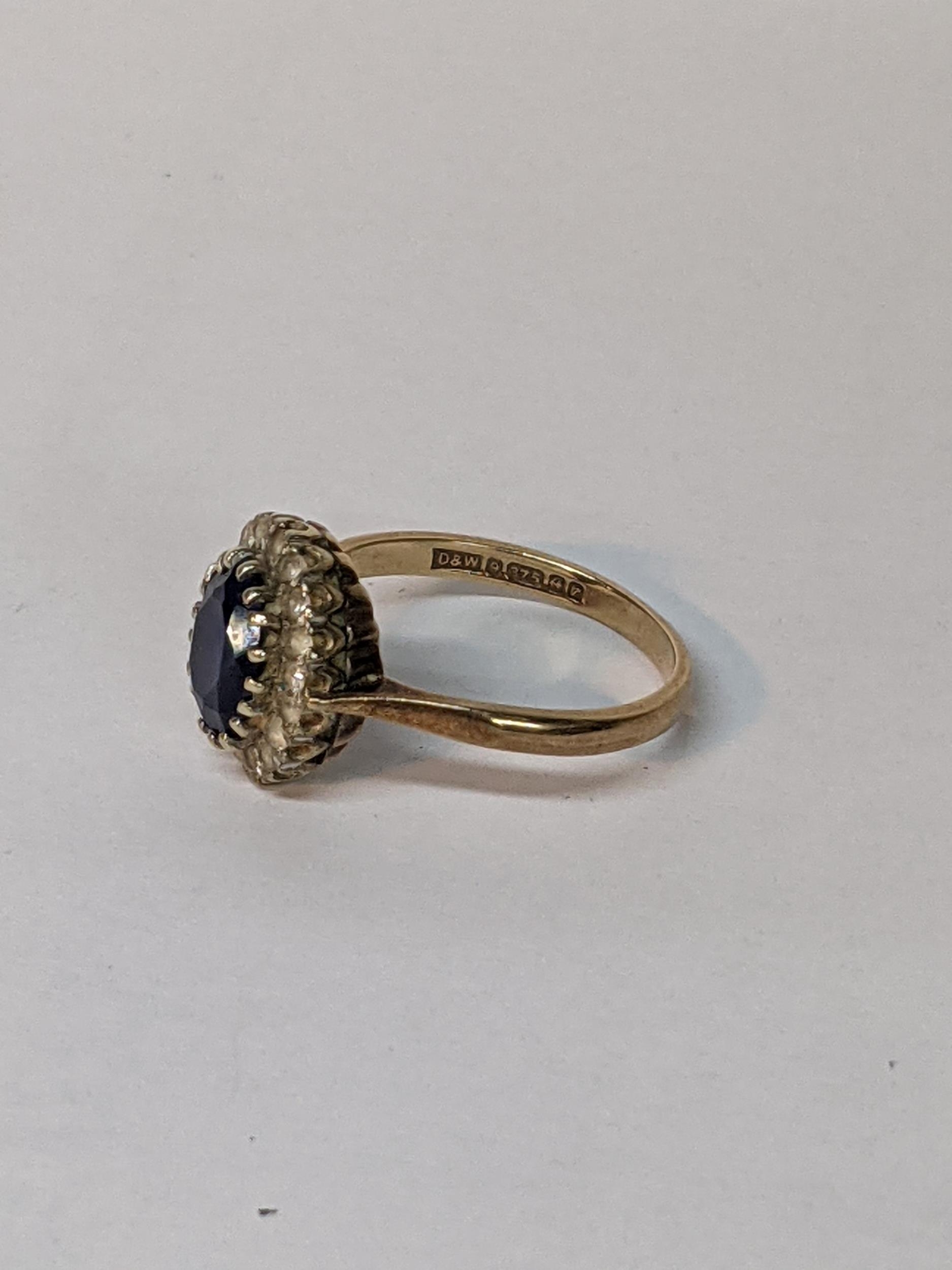 A 9ct rose gold ring set with an oval blue stone (possibly a heavily treated sapphire) surrounded by - Image 2 of 2