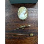A yellow metal cameo carved brooch together with a yellow metal diamond inset stick pin and a yellow