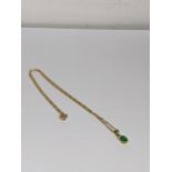 AN 18ct gold necklace inset with an oval cut emerald inset with two diamonds, total weight 3.4g