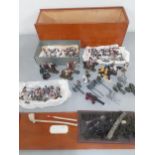 A quantity of painted lead and Airfix soldiers in a treen box together with mixed canons and other