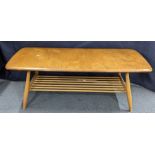 A vintage Ercol blonde elm and beech coffee table of rectangular form and magazine rack below,